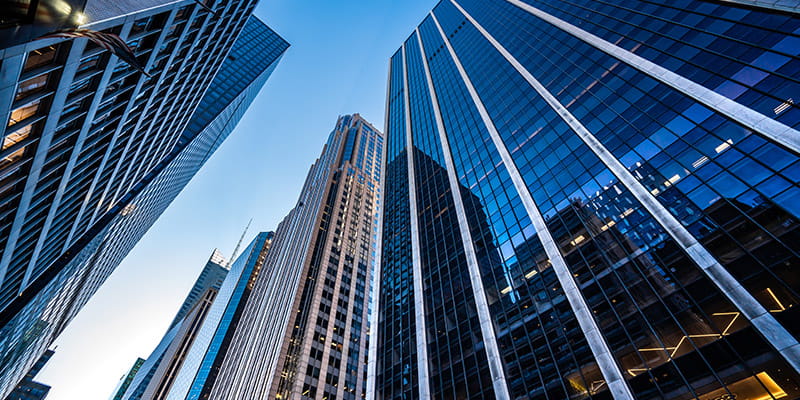 Skyline view featuring tall buildings against a clear blue sky used in Australian M&A Deal Report 2026- Australian Bidders Chapter.