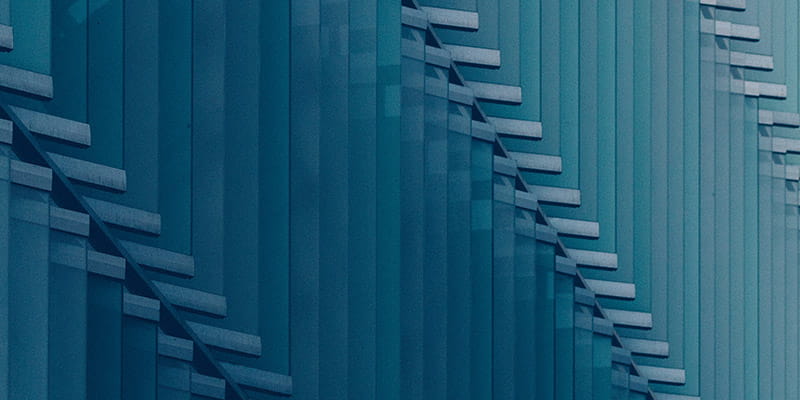 A blue wall featuring a geometric pattern of square used in Australian M&A Deal Report 2026- Target sectors chapter.