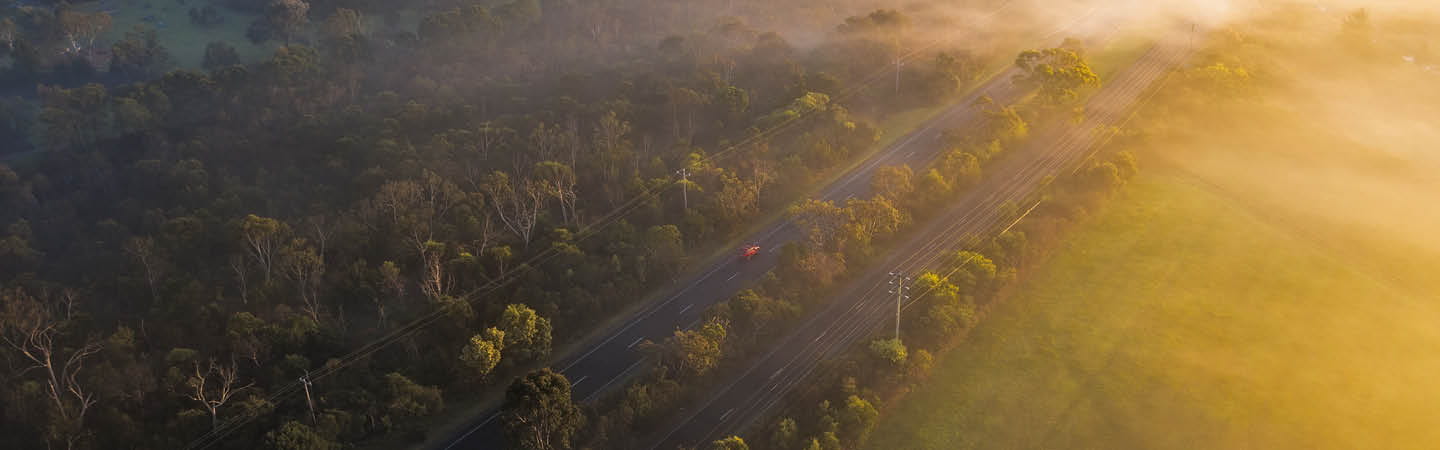 Aerial rural road through bushland and farmland at sunrise, used in the Environment and planning year in review 2025