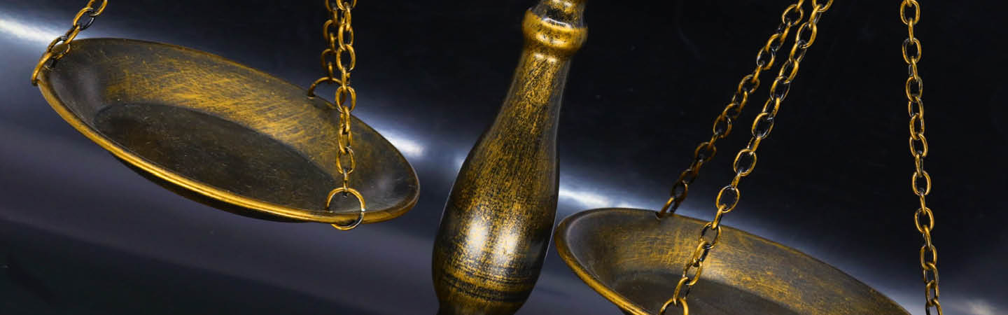 Antique brass scales of justice on a dark background, used in the Environment and Planning Year in Review 2025