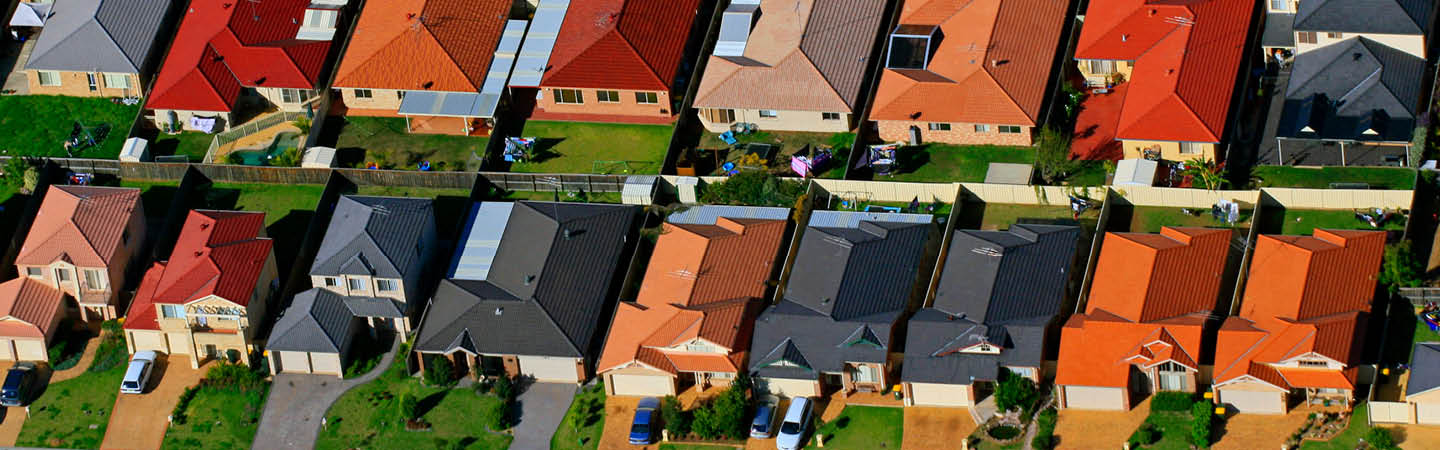 Aerial view of an Australian suburban housing estate with colourful rooftops. Used in the Environment and planning year in review 2025.