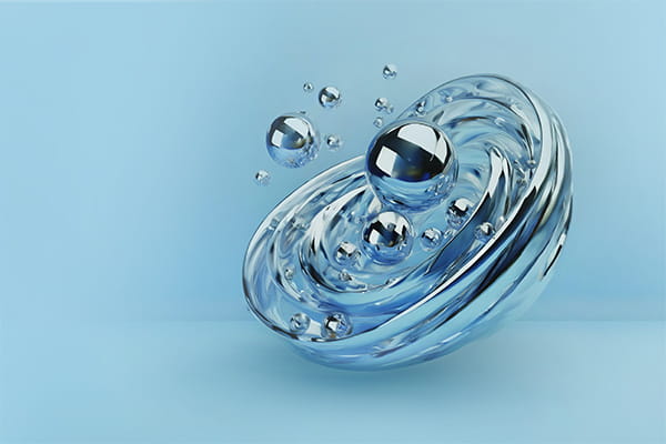 A reflective metal sphere floating in clear water, creating ripples around it.
